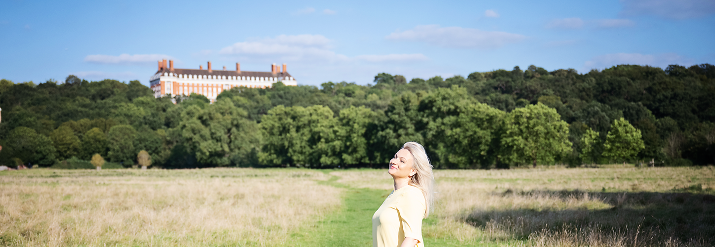Elizabeth Adams in a flowing yellow dress in a sunlit meadow